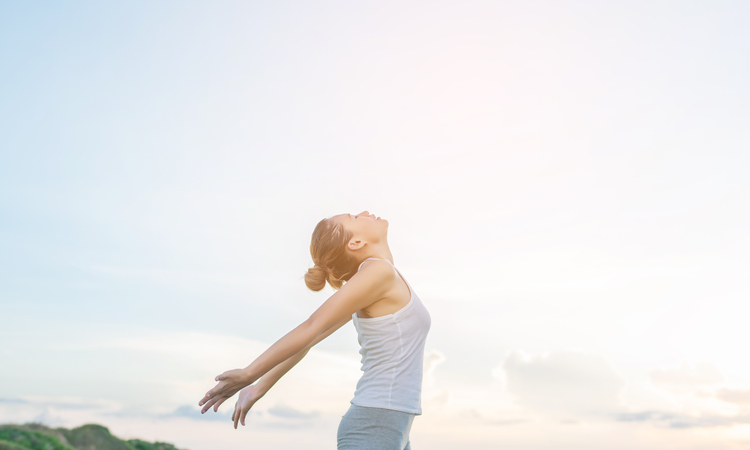Concentrated Woman Stretching Her Arms With Sky Background