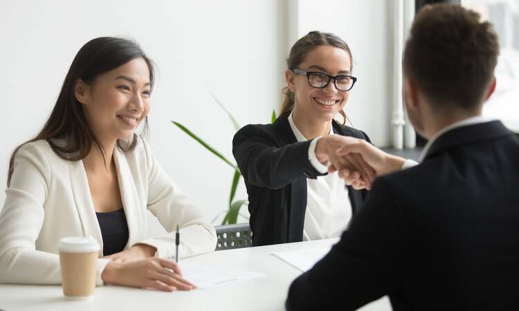 Businessman Shaking Hand Female Coworker During Company Meeting Min